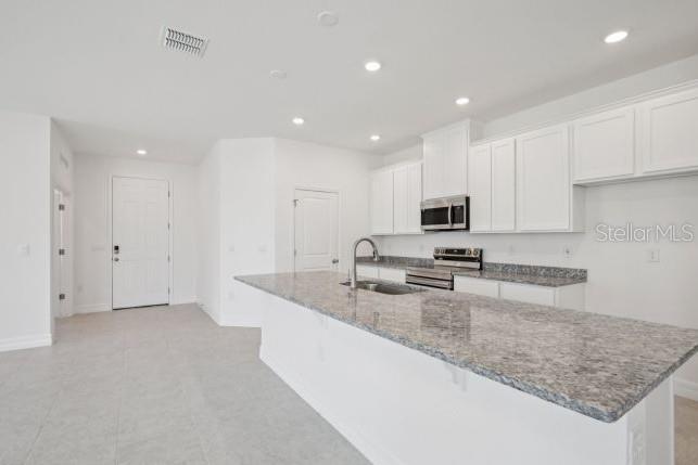 A kitchen with white cabinets, granite countertops, a large island, and stainless steel appliances — 2116 RIO DE JANEIRO AVENUE, PUNTA GORDA, FL