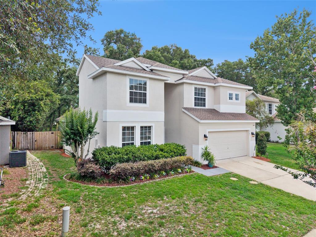 A two-story suburban house with a beige stucco exterior, a garage, and a front lawn — 2563 WALNUT HEIGHTS ROAD, APOPKA, FL