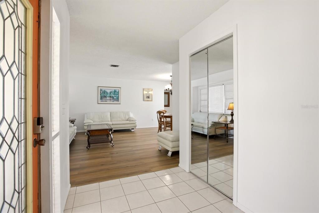 An entryway with tiled flooring leads into a living room featuring wood-look flooring — 747 BAL HARBOR BOULEVARD, PUNTA GORDA, FL