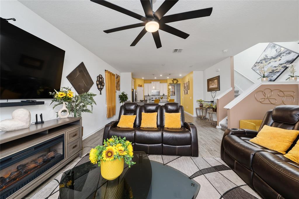 A living room features dark leather recliners, a glass coffee table, and a fireplace console — 2369 VOLUNTEER AVENUE, KISSIMMEE, FL