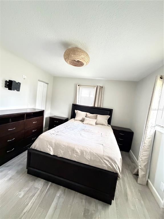 A bedroom features a dark wood bed frame, matching nightstands, a dresser, and light flooring — 125 SE 6TH AVENUE, BOYNTON BEACH, FL