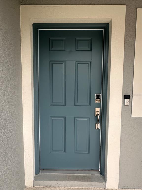 A teal six-panel front door with a keypad lock and doorbell camera — 2358 PARAVANE WAY, WESLEY CHAPEL, FL