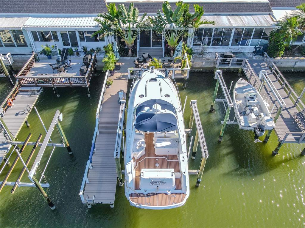 An aerial view shows a boat docked at a pier next to a waterfront house — 345 BOCA CIEGA POINT BOULEVARD, ST PETERSBURG, FL