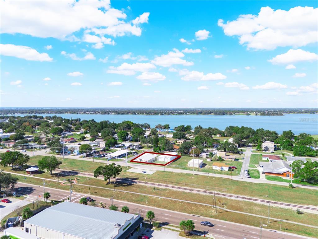 An aerial view shows a property outlined in red near a large lake and railroad tracks — 109 N 3RD STREET, EAGLE LAKE, FL