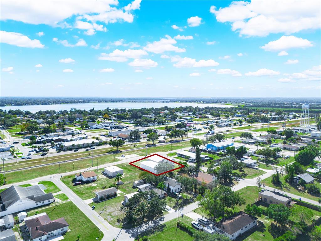 An aerial view shows a residential neighborhood with a red-outlined house near a lake — 109 N 3RD STREET, EAGLE LAKE, FL