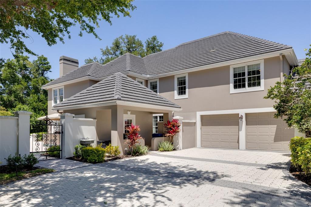 A two-story house with a paved driveway, a two-car garage, and a gated side entrance — 97 SUGAR MILL DRIVE, OSPREY, FL