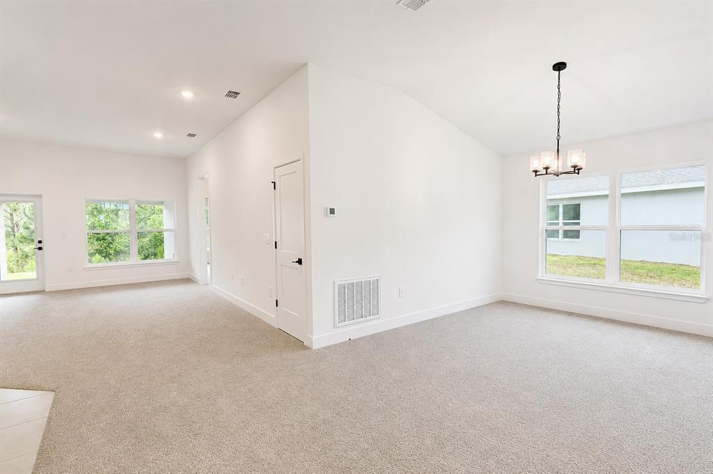 A room with white walls, carpeted flooring, and two white doors leading to other spaces — 7592 BENT TREE LOOP, ST CLOUD, FL