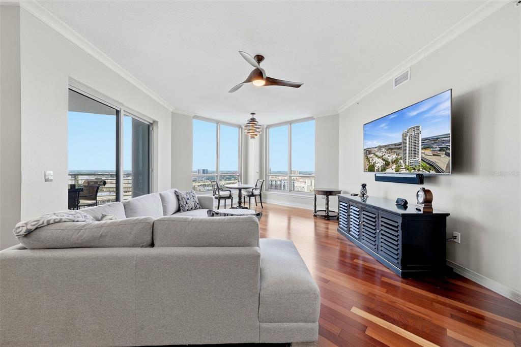 A living room with hardwood floors, a gray sectional sofa, and floor-to-ceiling windows — 449 SOUTH  12TH UNIT 2301, TAMPA, FL