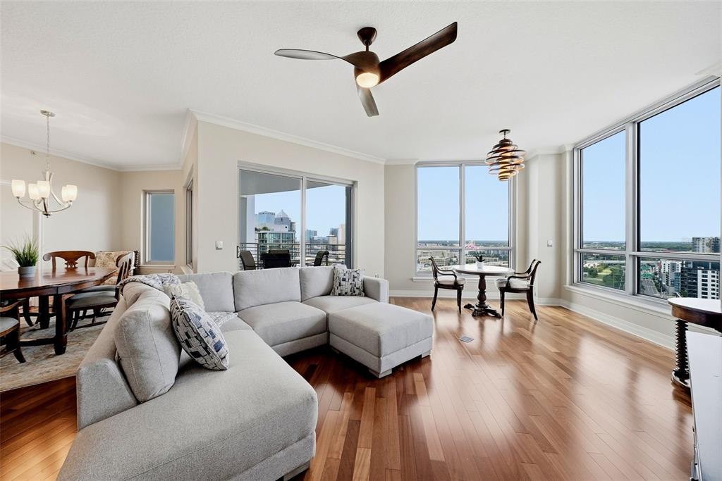 A living room with a sectional sofa, hardwood floors, a ceiling fan, and floor-to-ceiling windows — 449 SOUTH  12TH UNIT 2301, TAMPA, FL