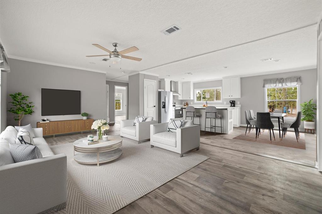 An open-concept living area with gray walls, wood-look flooring, and a kitchen with white cabinets — 20213 NW 258TH STREET, OKEECHOBEE, FL