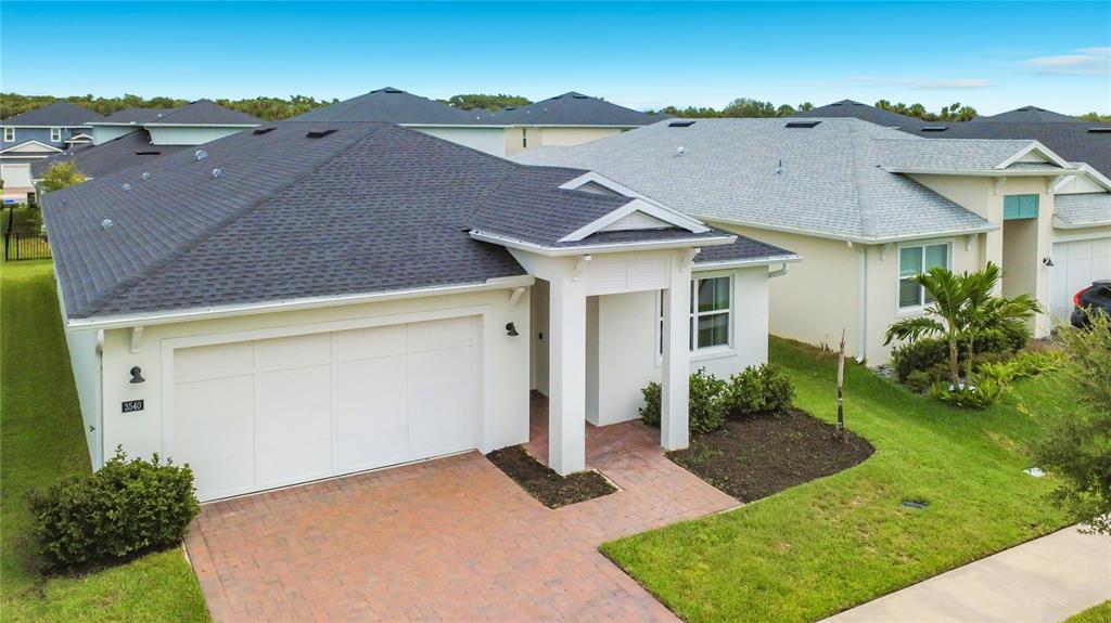An aerial view shows three suburban houses with paved driveways and gray shingled roofs — 3540 STONEBRIAR LANE, SANFORD, FL
