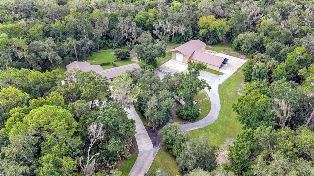 An aerial view shows a house and a large detached garage with a metal roof — 6400 FORESTWOOD DRIVE E, LAKELAND, FL