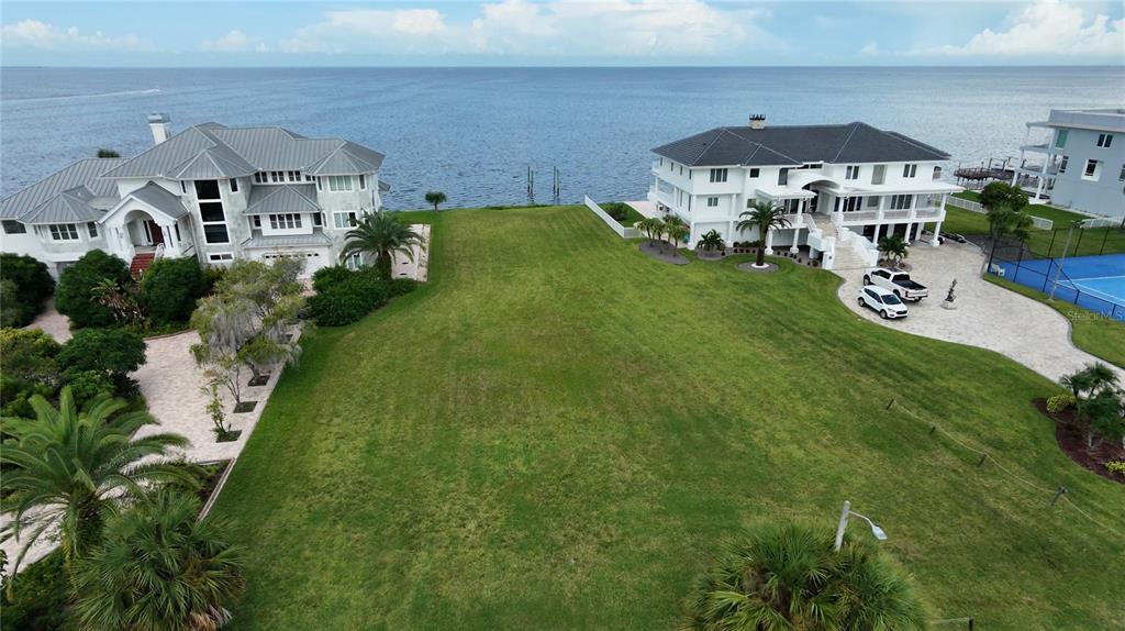 A bright sun sets over the ocean, casting a reflection on the sandy beach — 21 WESTSHORE DRIVE, NEW PORT RICHEY, FL