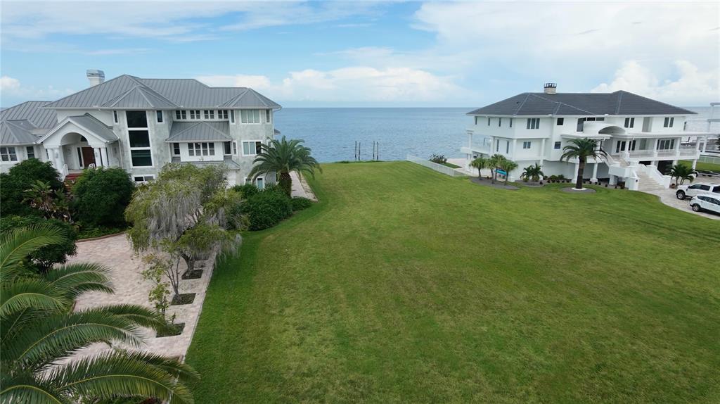 An aerial view of a sandy beach along a blue bay with coastal residential homes — 21 WESTSHORE DRIVE, NEW PORT RICHEY, FL