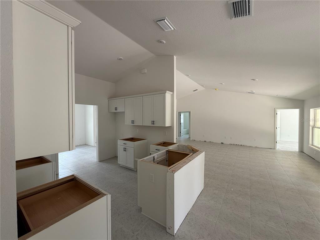 A single-story house under construction with concrete block walls and a blue underlayment roof — 8744 SE 162ND STREET, SUMMERFIELD, FL