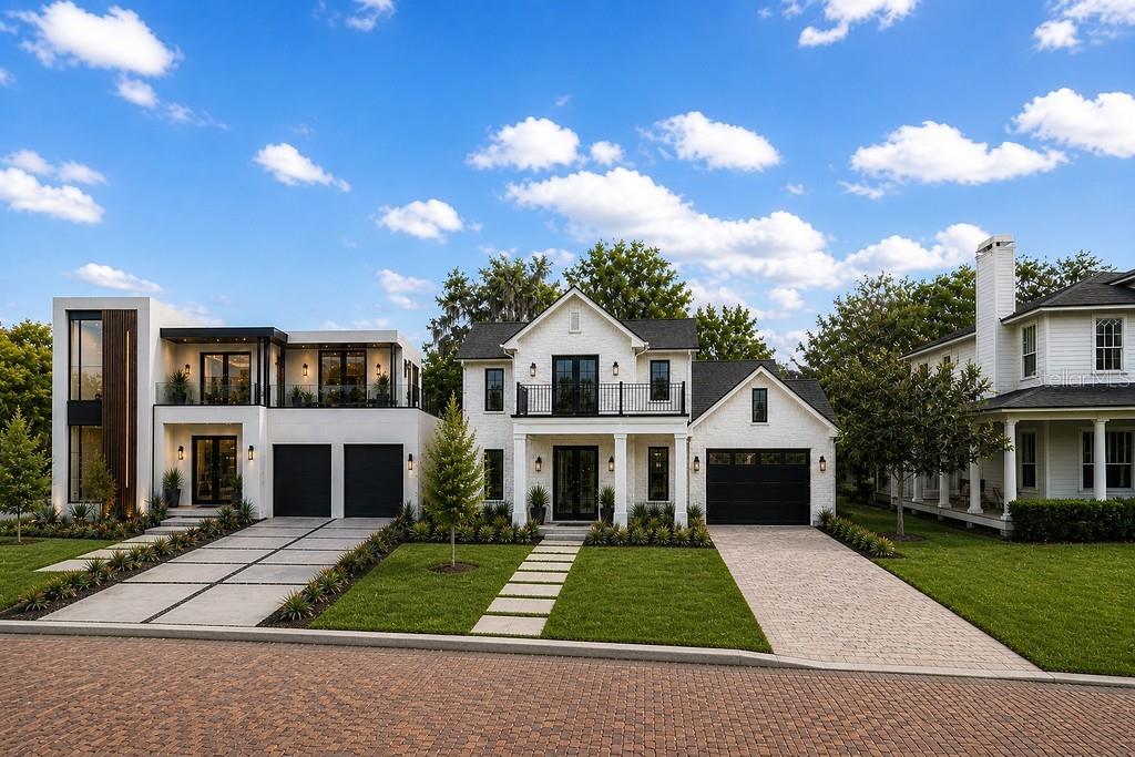 A modern white house with a black-trimmed exterior stands next to a traditional home — 230 KILLARNEY DRIVE, WINTER PARK, FL