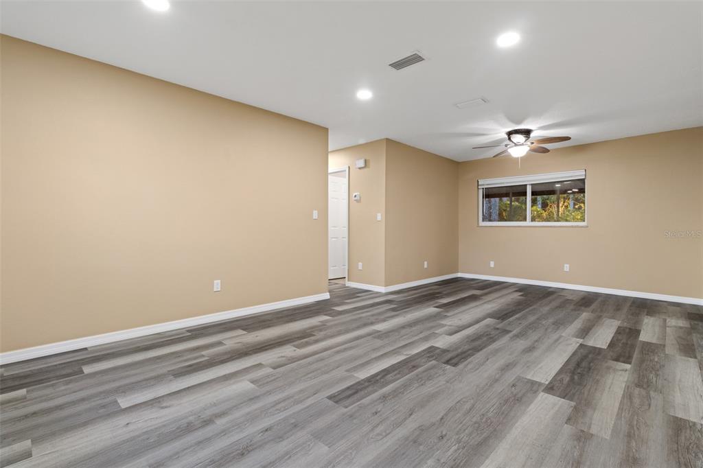 An empty room with tan walls, recessed lighting, a ceiling fan, and wood-look flooring — 609 HOLLEY STREET, BROOKSVILLE, FL