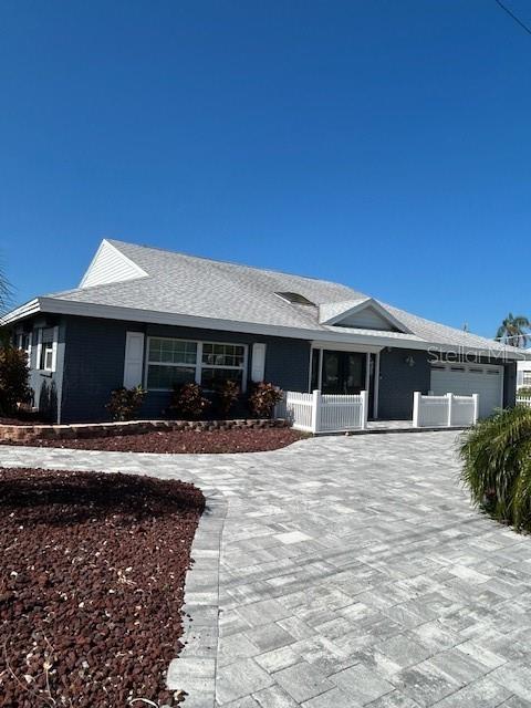A single-story house with gray siding, a shingled roof, and a paved driveway — 9312 KINGSTON ROAD, BRADENTON, FL