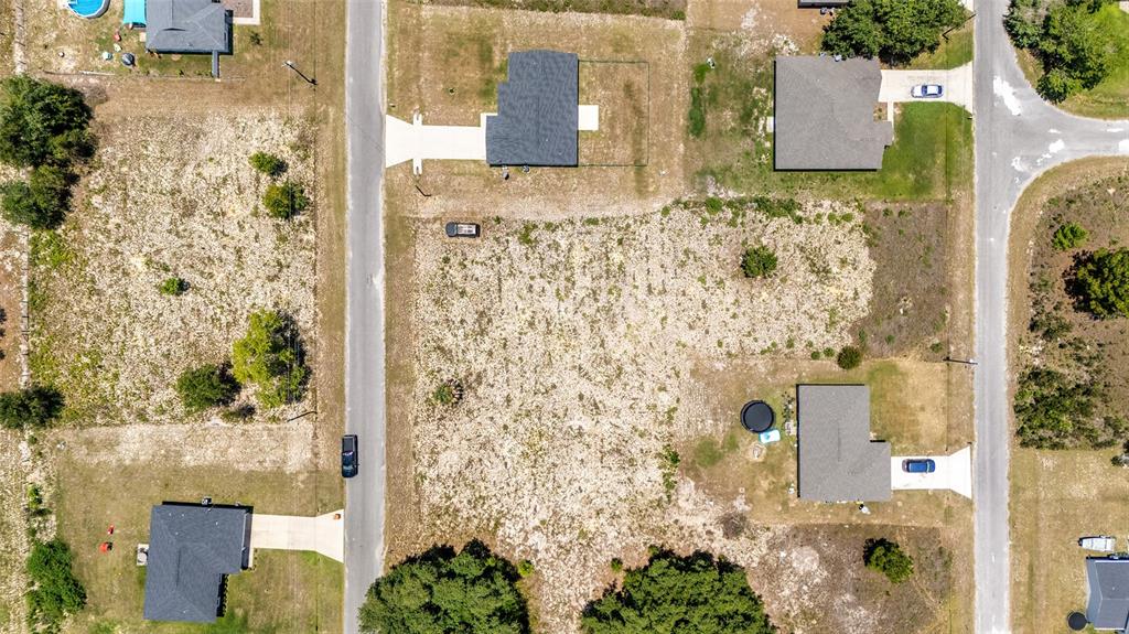 This aerial view shows several residential houses and a large vacant lot — 0 MALAUKA LOOP, OCKLAWAHA, FL