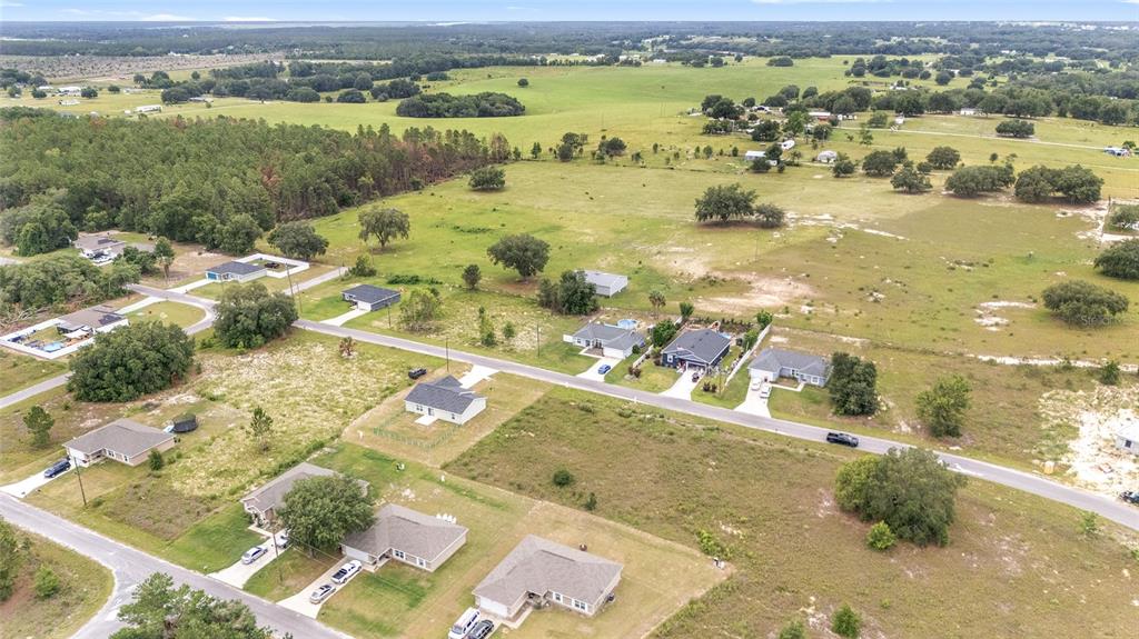 An aerial view shows several single-family homes situated on large, grassy lots near a forest — 0 MALAUKA LOOP, OCKLAWAHA, FL