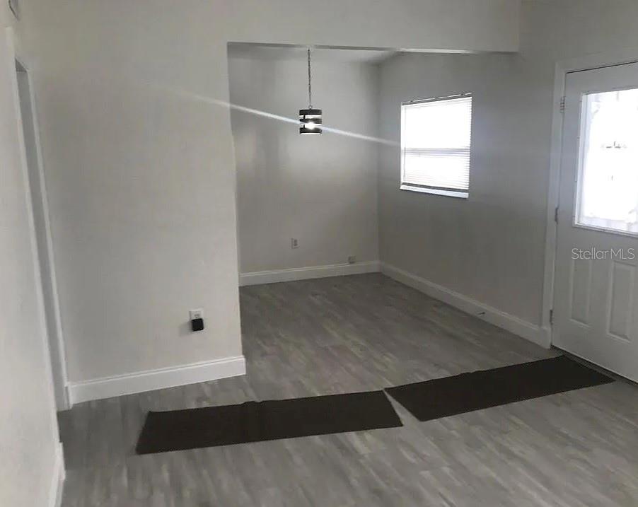 An interior view shows a dining area with gray wood-look flooring and a pendant light — 1200 EMERALDA RD, ORLANDO, FL