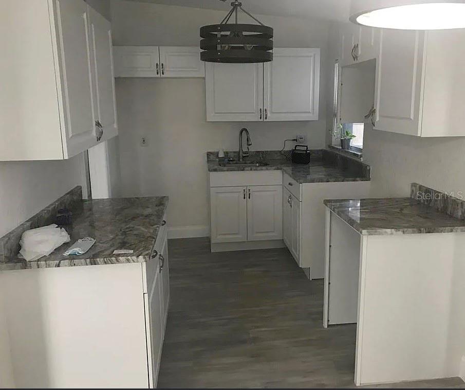 A kitchen with white cabinets, gray granite countertops, and wood-look flooring — 1200 EMERALDA RD, ORLANDO, FL