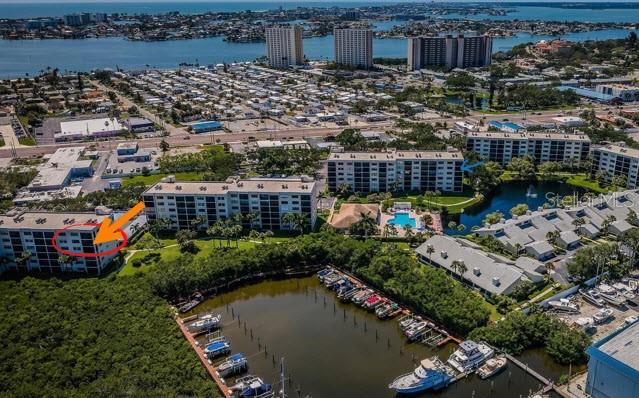An aerial view shows a multi-story apartment building with a red circle and orange arrow — 1332 PASADENA AVENUE S UNIT 501, SOUTH PASADENA, FL