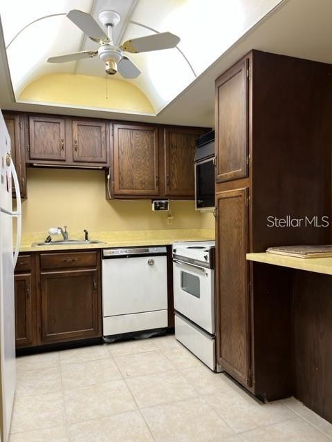 A kitchen with dark wood cabinets, white appliances, a ceiling fan, and light-colored tile flooring — 627 MIDWAY DRIVE UNIT B, OCALA, FL