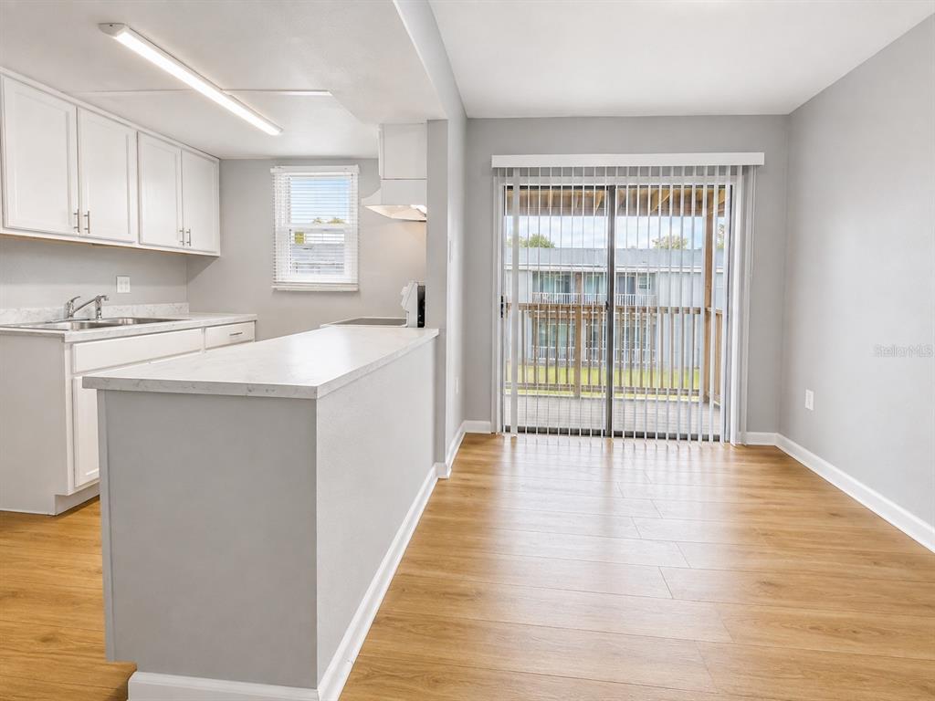 A kitchen with white cabinets and a breakfast bar opens to a dining area — 2763 L B MCLEOD ROAD UNIT C, ORLANDO, FL
