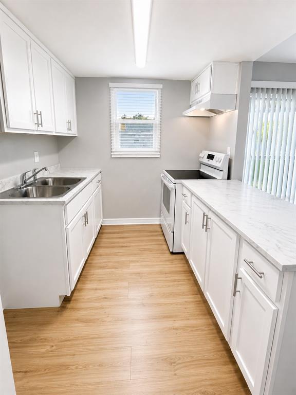 A kitchen with white cabinets, marble-look countertops, stainless steel sink, and light wood-look flooring — 2763 L B MCLEOD ROAD UNIT C, ORLANDO, FL