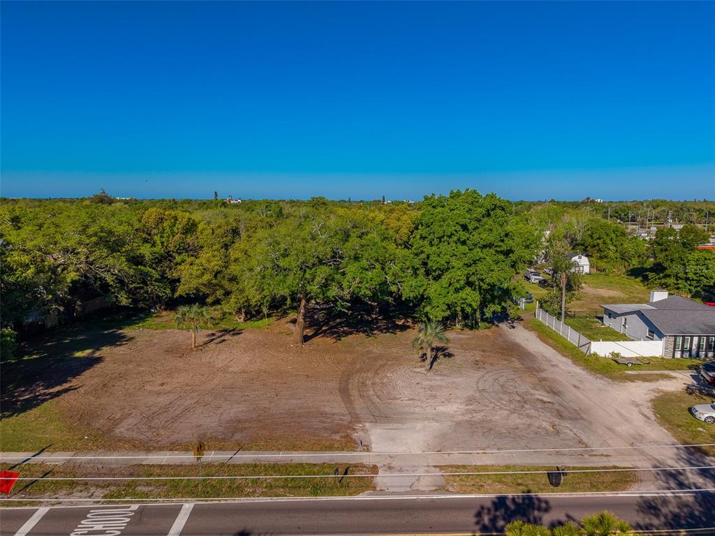 An aerial view shows a cleared, vacant residential lot with several mature trees — 11625 131ST STREET, LARGO, FL