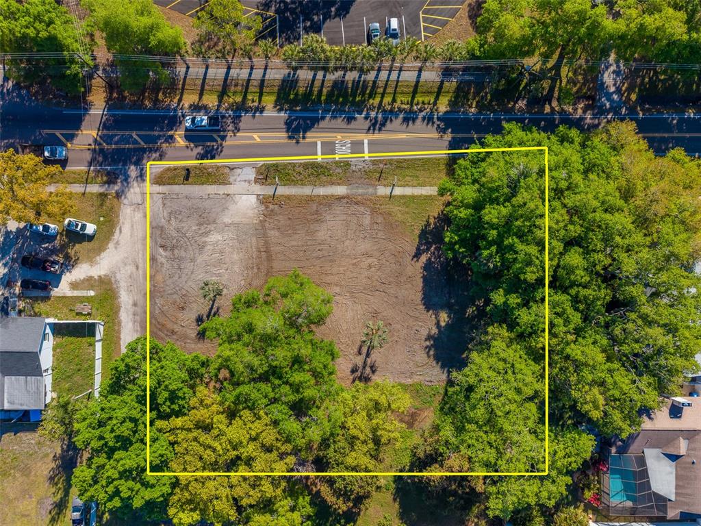 An aerial view shows a rectangular, cleared vacant lot bordered by trees and a road — 11625 131ST STREET, LARGO, FL