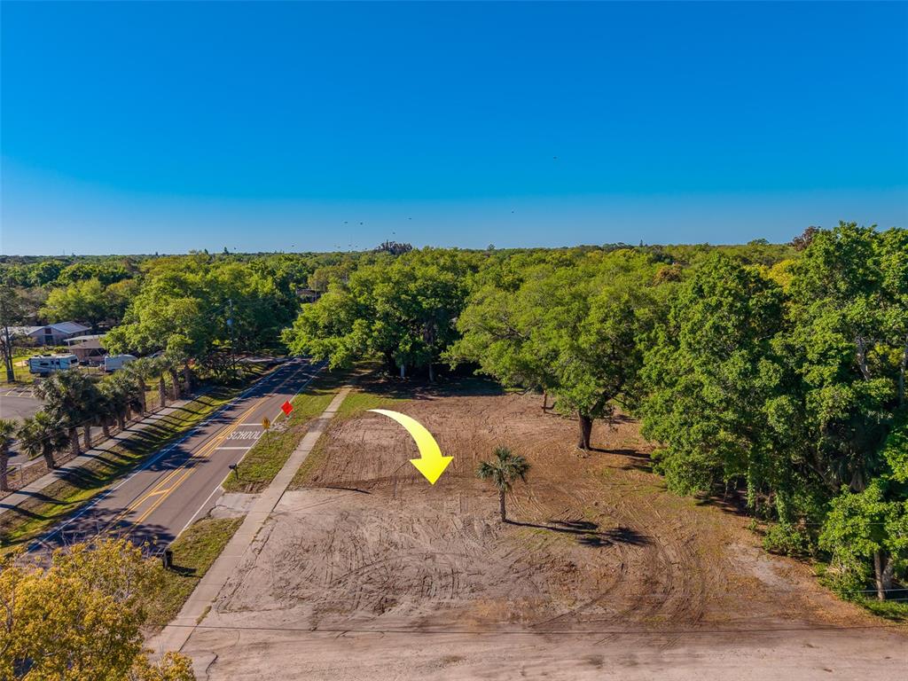An aerial view of a cleared, vacant lot bordered by a road and mature trees — 11625 131ST STREET, LARGO, FL