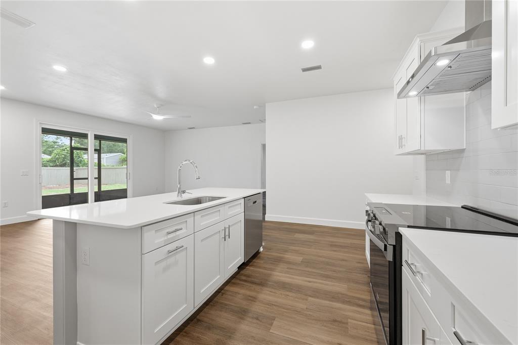 A covered concrete patio features a ceiling fan and sliding glass doors leading indoors — 1132 SW 67TH WAY, GAINESVILLE, FL