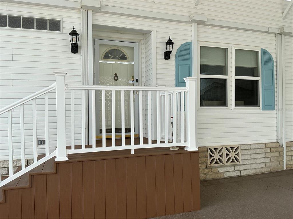 A white house features a screened-in porch, a garage, and a palm tree in front — 236 ALLIES PASS PASS UNIT 363, FROSTPROOF, FL