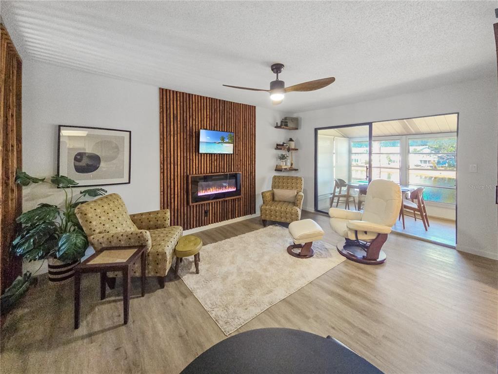 A living room features a wood-slat accent wall with a fireplace, television, and sliding doors — 623 MIDWAY DRIVE UNIT B, OCALA, FL