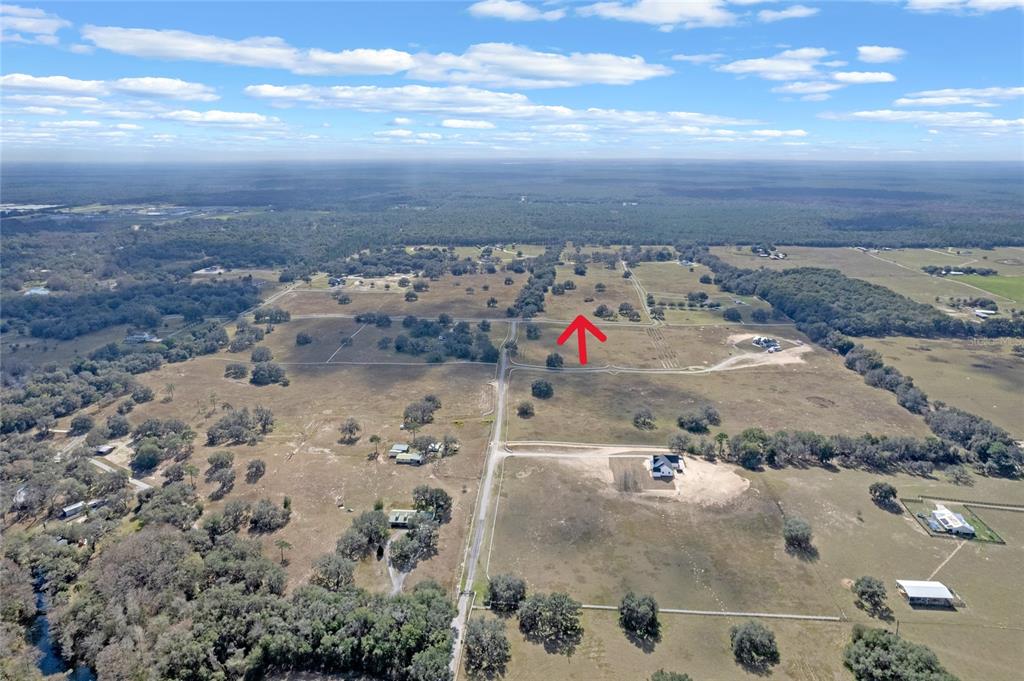 An aerial view shows a large, open rural landscape with scattered trees and dirt roads — 14 EAGLE RIDGE, BUSHNELL, FL