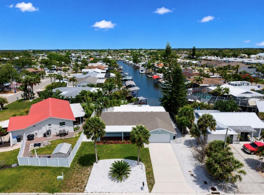 An aerial view shows a residential street with houses, a canal, and boat docks — 6513 ABACO DRIVE, APOLLO BEACH, FL
