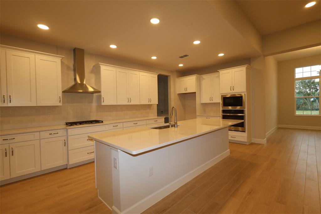 A bathroom features a vanity with a sink, a large mirror, and a glass-paneled door — 3223 ROSEVILLE DRIVE, APOPKA, FL