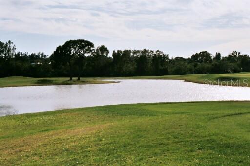 A view of a pond on a golf course with trees in the background — 10 WINDWARD PLACE, PLACIDA, FL