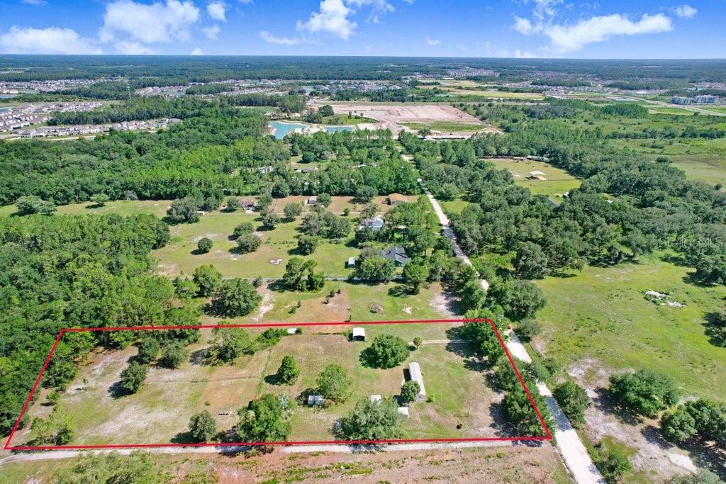 An aerial view shows a rectangular plot of land outlined in red with several small structures — 3320 TINA MARIE DRIVE, WESLEY CHAPEL, FL