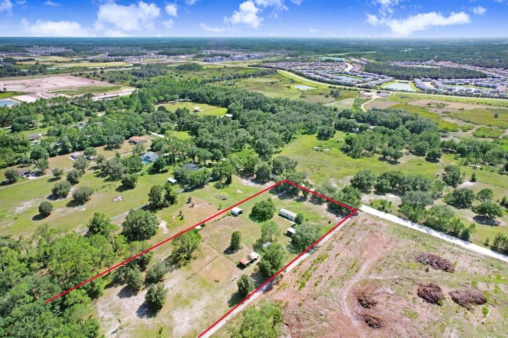 An aerial view shows a rural property outlined in red, featuring a house and outbuildings — 3320 TINA MARIE DRIVE, WESLEY CHAPEL, FL