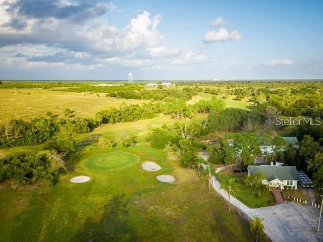 An aerial view shows a golf course green, surrounding trees, and a nearby residential house — 1503 S HIGHLAND PARK DRIVE, LAKE WALES, FL