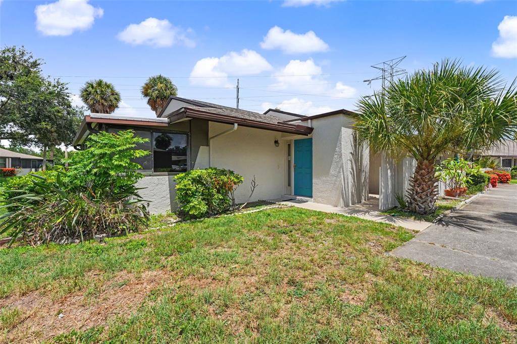 A white front door opens into a living area with light gray walls and wood flooring — 1502 16TH CIRCLE SE, LARGO, FL