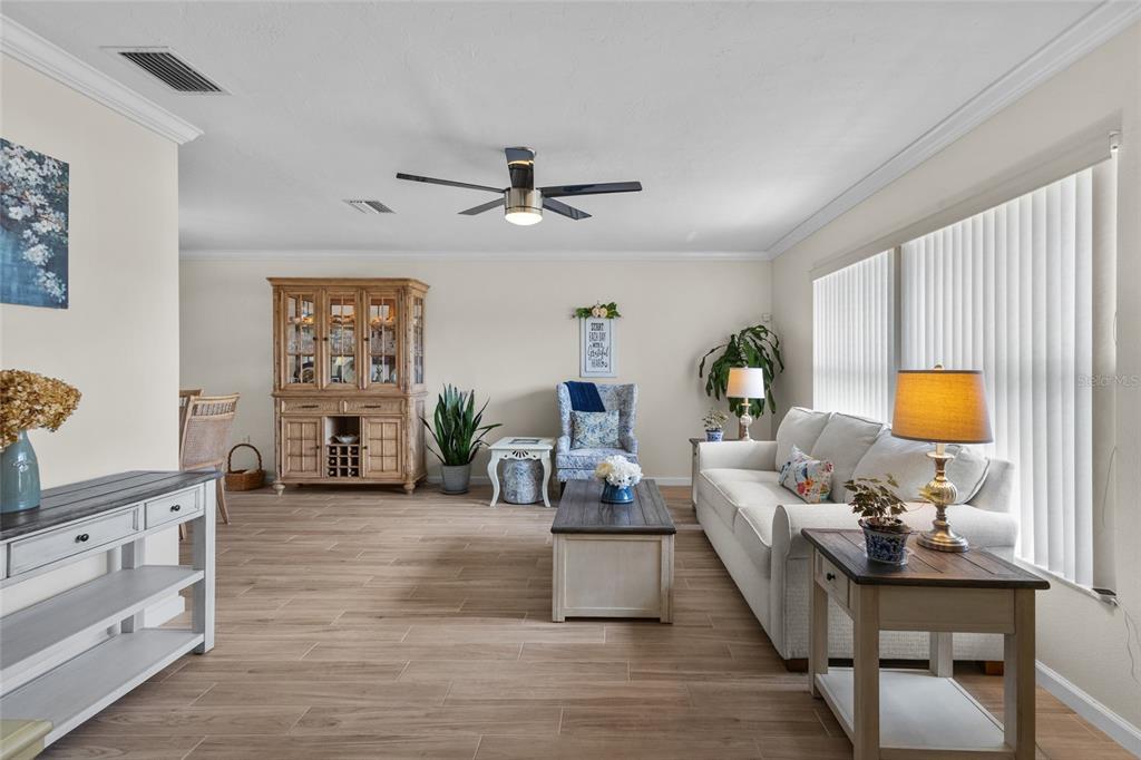 A living room features a beige sofa, wooden coffee table, and a large china cabinet — 6640 WATERFORD LANE, SARASOTA, FL