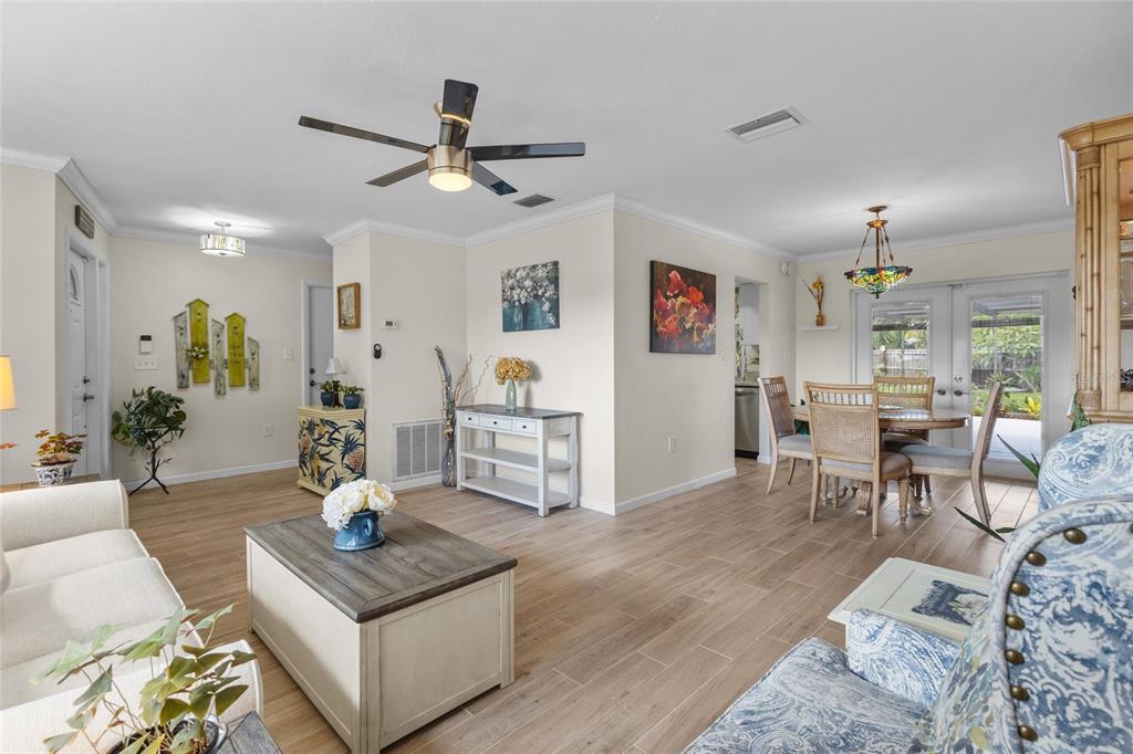 A living room and dining area with light wood-look tile flooring and a ceiling fan — 6640 WATERFORD LANE, SARASOTA, FL