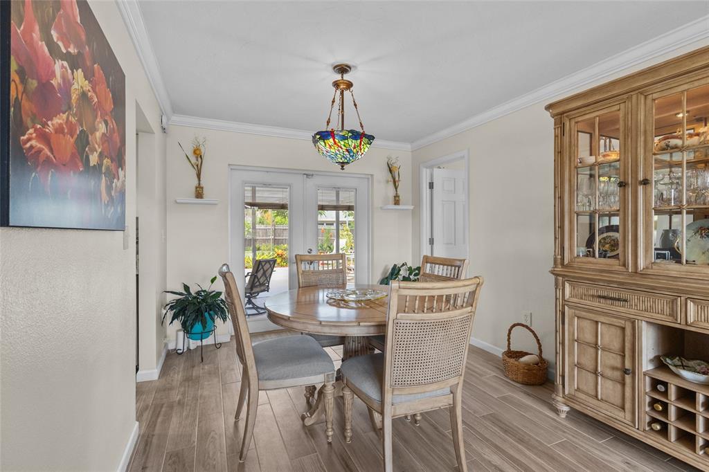 A dining room features a round wooden table, four chairs, a hutch, and glass doors — 6640 WATERFORD LANE, SARASOTA, FL