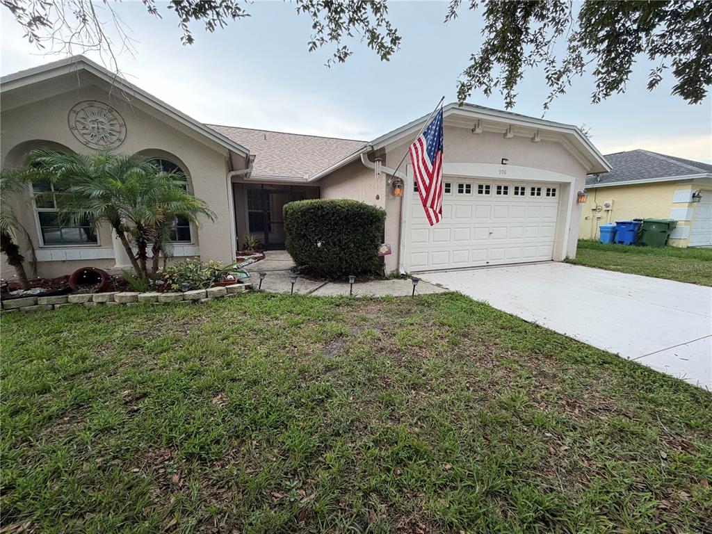The exterior of a house features a palm tree, a large hedge, and a walkway — 908 45TH STREET E, BRADENTON, FL