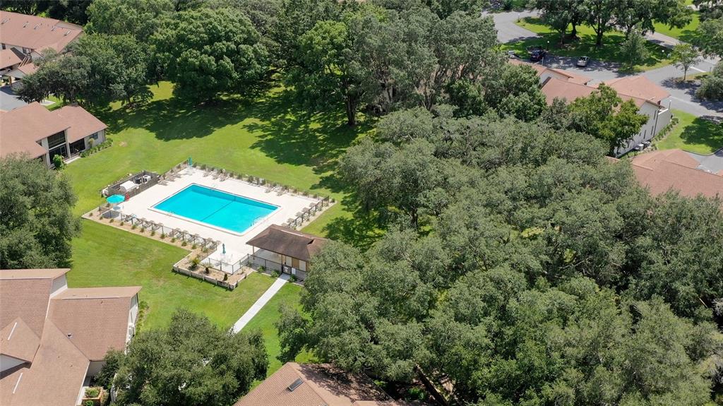 An aerial view shows a rectangular swimming pool, a small cabana, and surrounding apartment buildings — 95 E HARTFORD STREET UNIT 7A, HERNANDO, FL
