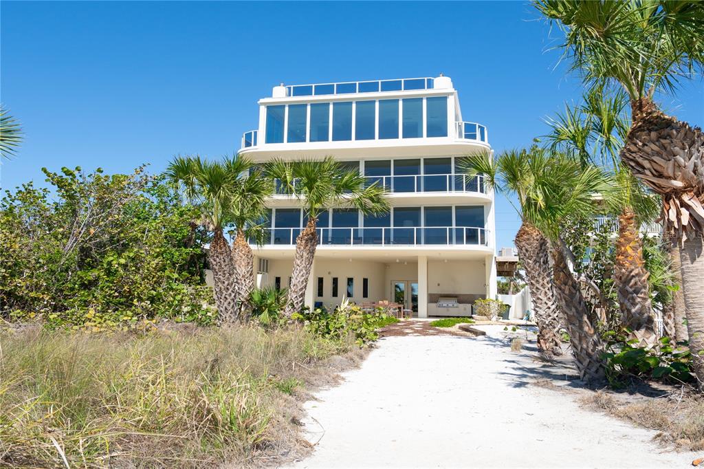 An aerial view of a modern beachfront house with a curved roof and multiple balconies — 534 BEACH ROAD, SARASOTA, FL